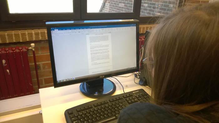 Eleve devant un ordinateur durant le cours de traitement de texte